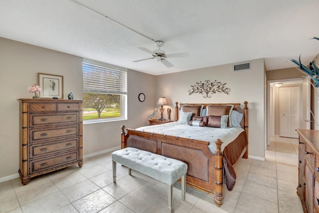 bedroom featuring light tile patterned floors, ceiling fan, visible vents, and baseboards