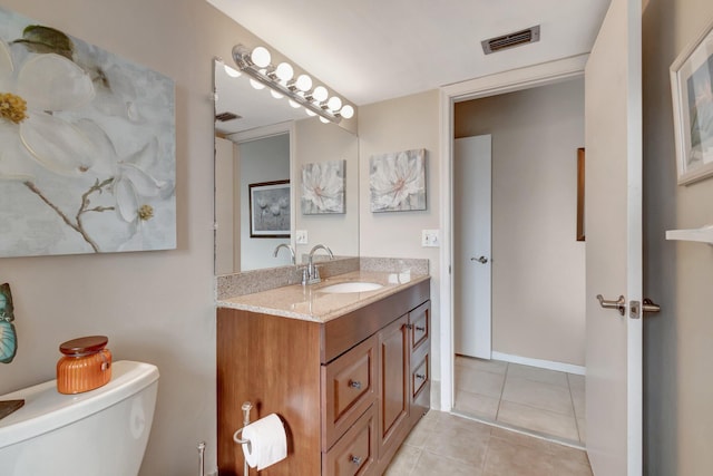 bathroom with tile patterned flooring, toilet, vanity, visible vents, and baseboards