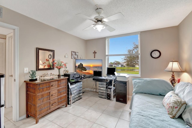 interior space featuring ceiling fan, a textured ceiling, and light tile patterned flooring