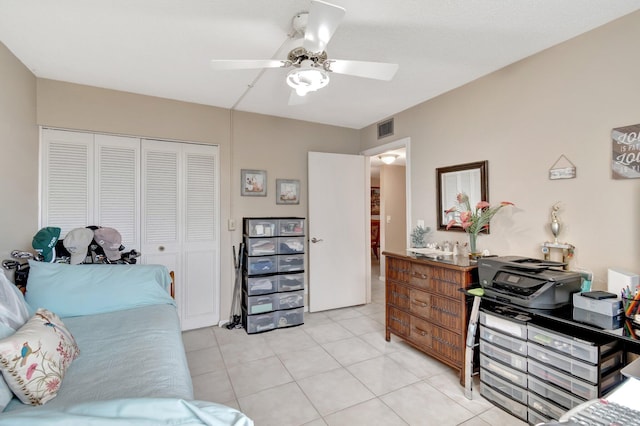 bedroom with ceiling fan, a closet, light tile patterned flooring, and visible vents