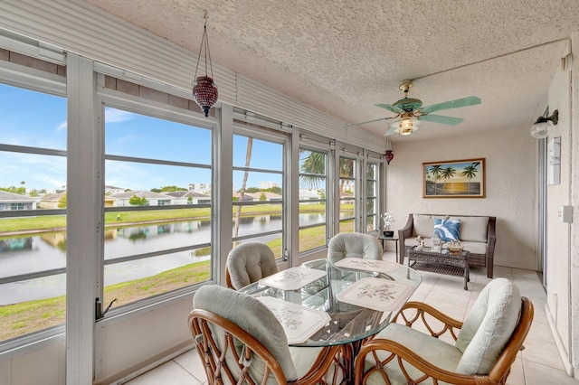 sunroom with a healthy amount of sunlight, a water view, and ceiling fan