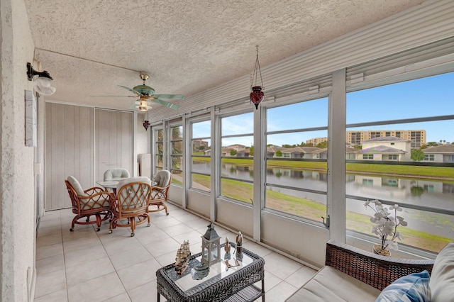 sunroom / solarium featuring a residential view, a water view, and ceiling fan