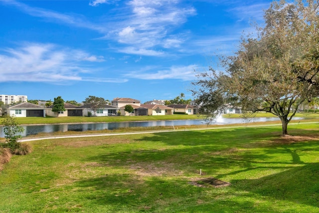 exterior space with a water view, a residential view, and a lawn