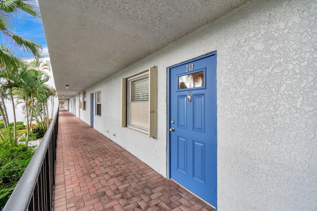 property entrance featuring a balcony and stucco siding