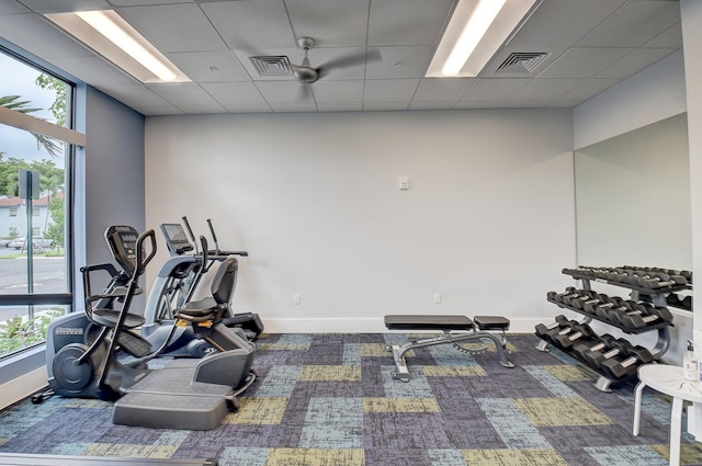 exercise room featuring a drop ceiling, visible vents, and baseboards