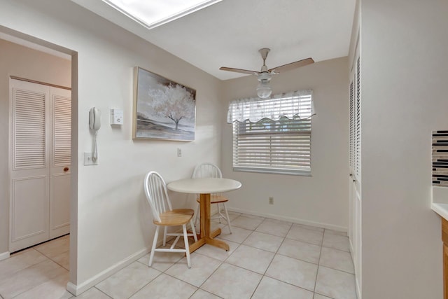 dining space featuring ceiling fan, light tile patterned floors, and baseboards