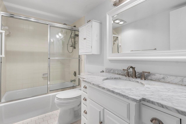 full bathroom with vanity, tile patterned flooring, shower / bath combination with glass door, and toilet