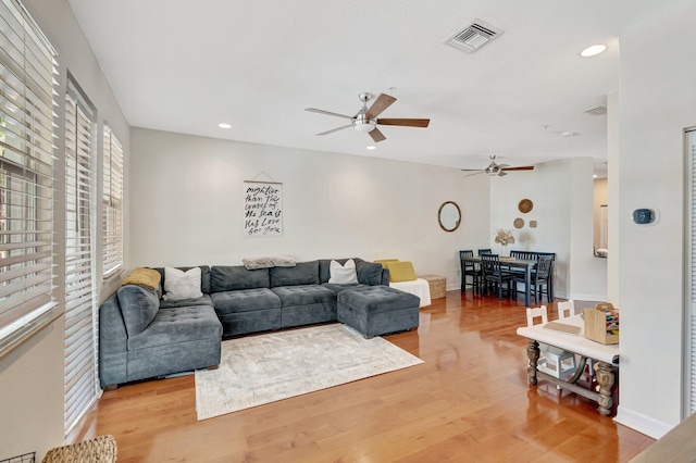 living room featuring ceiling fan and light hardwood / wood-style flooring