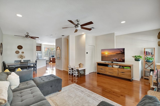 living room featuring ceiling fan and hardwood / wood-style floors