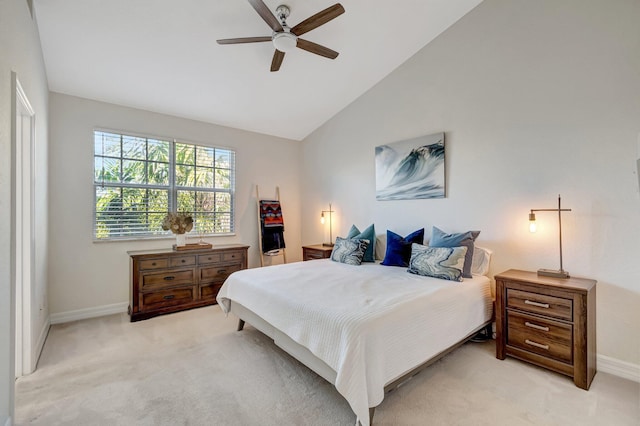 bedroom with ceiling fan, light colored carpet, and vaulted ceiling