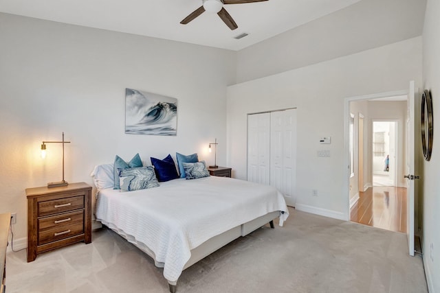 bedroom featuring light colored carpet, a closet, and ceiling fan