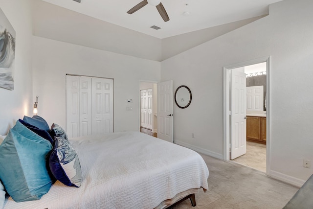 bedroom with connected bathroom, light carpet, ceiling fan, and a closet