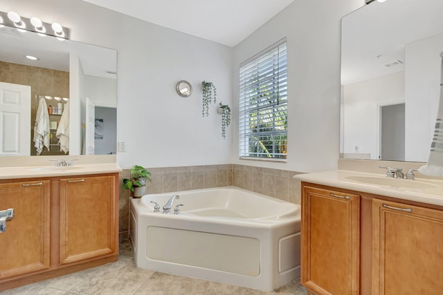 bathroom with tile patterned floors, vanity, and a washtub