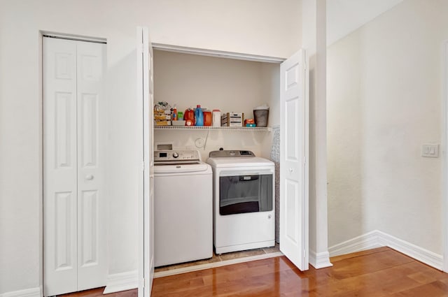 clothes washing area featuring hardwood / wood-style flooring and separate washer and dryer