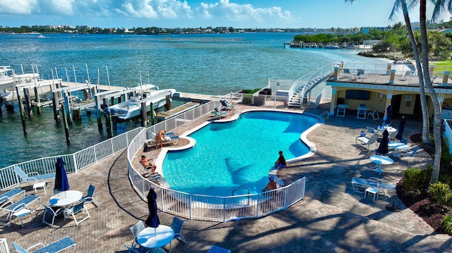 exterior space with a water view, a dock, and a patio area