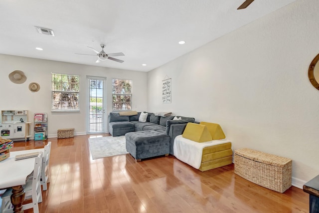 living room with ceiling fan and light wood-type flooring