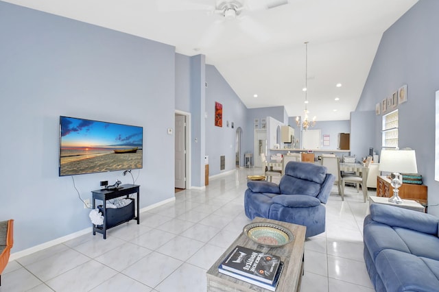 living room with ceiling fan with notable chandelier, high vaulted ceiling, and light tile patterned floors