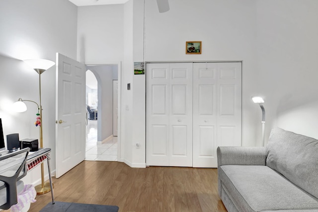 office area featuring a towering ceiling and wood-type flooring