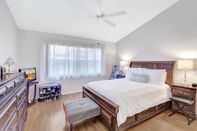 bedroom with ceiling fan, light hardwood / wood-style flooring, and vaulted ceiling