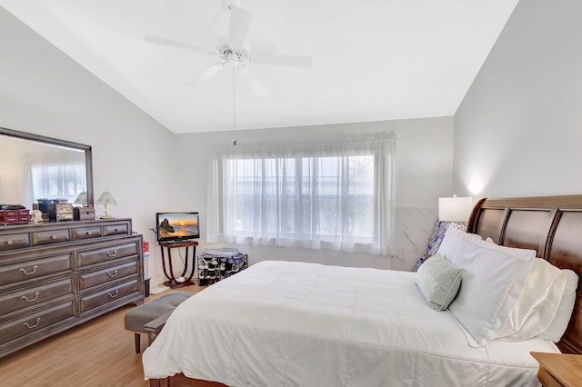 bedroom with light hardwood / wood-style floors, vaulted ceiling, and ceiling fan