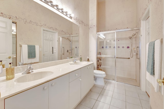 bathroom with tile patterned floors, toilet, vanity, and a shower with shower door