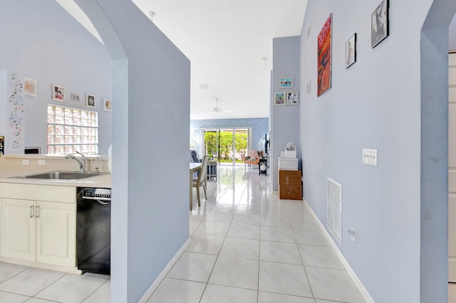 hall featuring light tile patterned floors and sink