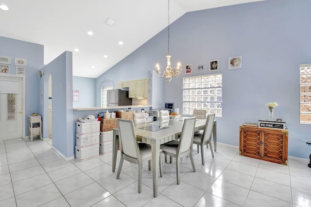 tiled dining area with high vaulted ceiling, a chandelier, and a wealth of natural light