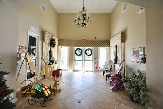 tiled entryway featuring a notable chandelier and a high ceiling