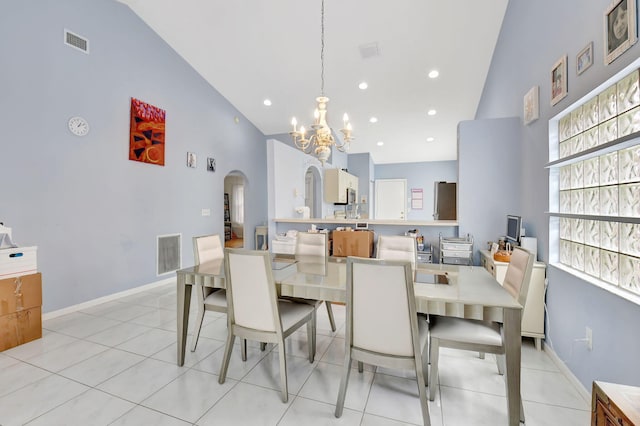 dining area featuring high vaulted ceiling, light tile patterned flooring, and an inviting chandelier