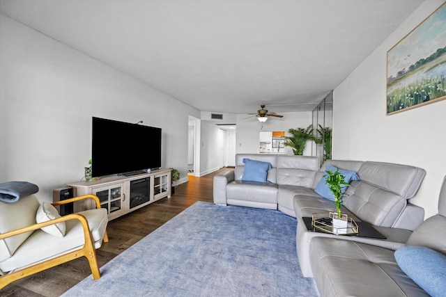 living room with dark wood-type flooring and ceiling fan