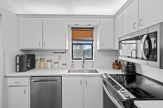 kitchen with stainless steel appliances, sink, and white cabinets