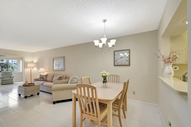 dining room with light tile patterned flooring, a chandelier, and a textured ceiling