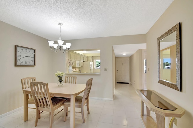 tiled dining space with an inviting chandelier and a textured ceiling