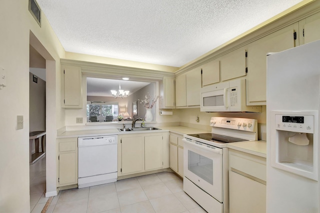 kitchen featuring cream cabinets, white appliances, and sink