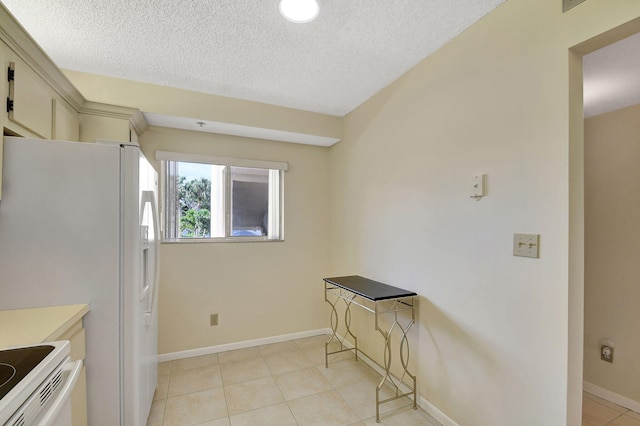 kitchen with white appliances, a textured ceiling, and light tile patterned floors