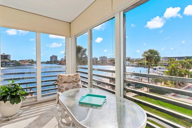 sunroom / solarium featuring a view of city and a water view