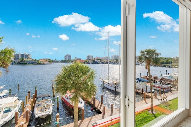 view of dock featuring a water view, a balcony, and a view of city