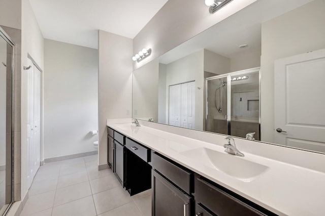 full bath featuring double vanity, toilet, tile patterned floors, a shower stall, and a sink