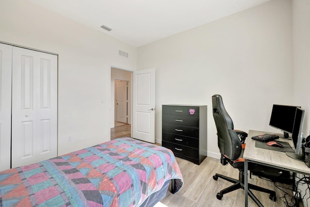 bedroom featuring baseboards, a closet, visible vents, and light wood-style floors