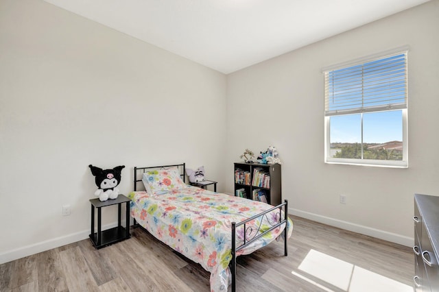 bedroom with baseboards and light wood finished floors