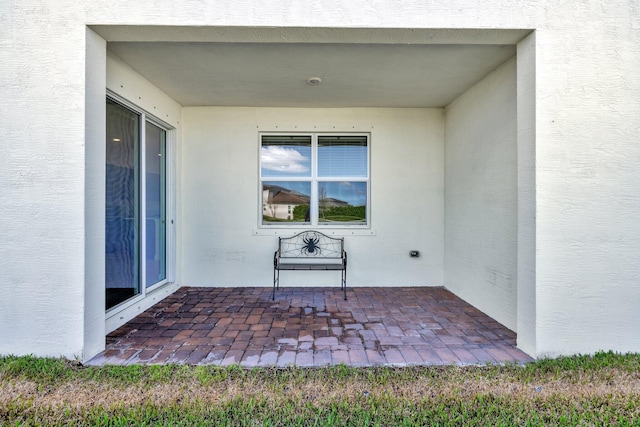 entrance to property featuring a patio and stucco siding