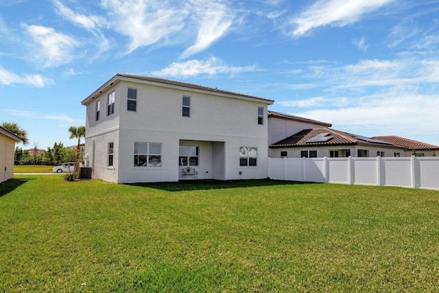 back of house featuring cooling unit, fence, and a lawn