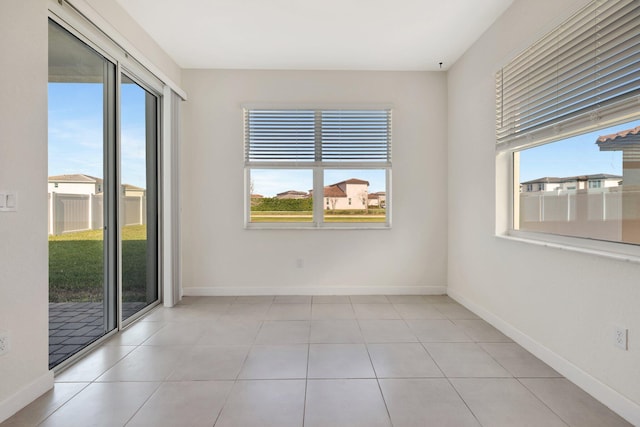 unfurnished room with plenty of natural light and baseboards