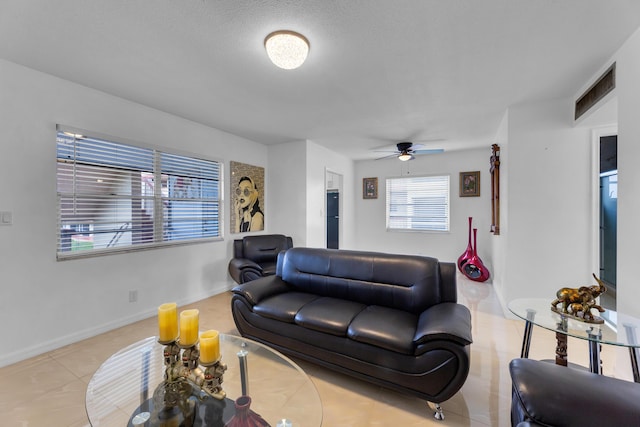 living area featuring visible vents, baseboards, a ceiling fan, and tile patterned flooring