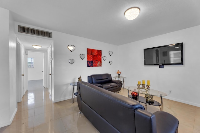 living area with light tile patterned floors, visible vents, and baseboards