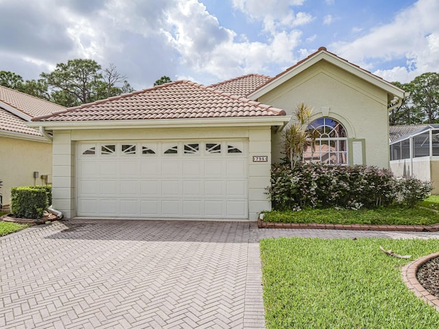 mediterranean / spanish-style house with a garage and a front yard