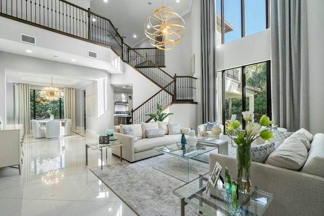 living room with visible vents, stairway, and an inviting chandelier