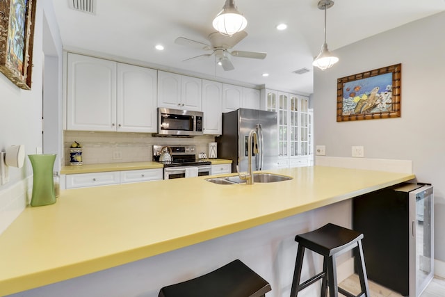 10174 Dogwood Ave, Palm Beach Gardens, FL 33410 - kitchen featuring stainless steel appliances, a sink, decorative backsplash, a peninsula, and recessed lighting