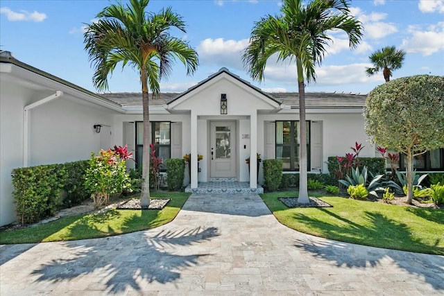 view of exterior entry with a yard