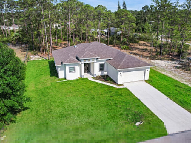 view of front of house featuring a garage and a front lawn